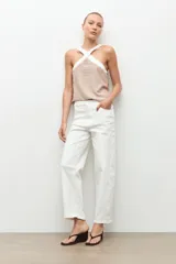 Jean barrel color blanco, de tiro alto y corte relajado con piernas curvas, estilo cropped y presillas en la cintura.