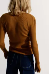 Remera de manga larga color marrón óxido, de tejido acanalado y corte entallado, con cuello redondo y tapeta de botones frontales.