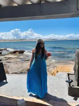 Vestido largo rojo, sin mangas, con escote en V pronunciado y corte amplio.