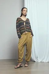 Pantalón barrel de lino color verde, de tiro medio con cintura elástica ajustable mediante cordón y bolsillos laterales.
