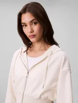 Buzo cropped con capucha y cierre frontal de Calvin Klein, confeccionado en punto milano. Presenta mangas largas con puños acanalados, dobladillo inferior también acanalado y cordones ajustables en la capucha.