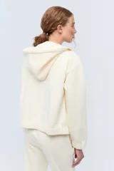 Campera deportiva con capucha confeccionada en tela elastizada texturada con diseño de flores.