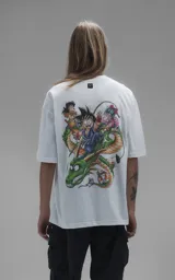 Remera blanca de corte oversize con cuello redondo y manga corta. Presenta una estampa central a todo color con personajes de Dragon Ball montados sobre el dragón Shenlong.