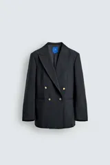 Blazer de corte regular confeccionada en lana, con diseño de botonadura cruzada y solapas de pico. Presenta mangas largas, bolsillos de vivo en el pecho y la cadera, un bolsillo interior y una abertura central en la espalda.