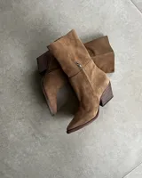 Botas de caña media color negro, confeccionadas en gamuza, con punta fina y taco geométrico.