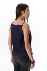Musculosa azul marino de lino con escote en V, breteles de cuero marrón y pespuntes blancos decorativos.