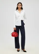 Bolso de mano tipo saco o 'balloon' de cuero sintético color rojo vibrante, con cordón ajustable en la parte superior y asas cortas.