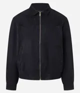 Campera masculina de estilo casual con cuello inglés, cierre frontal por cremallera, bolsillos laterales y ajuste elástico en el bajo. Presenta detalles de recortes en la parte superior delantera.