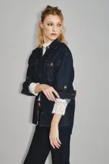 Camisa de jean de corte entallado con cierre frontal de botones, cuello clásico y mangas largas con puños ajustables. Presenta un diseño versátil ideal para combinar con diversas prendas.