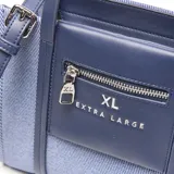 Cartera tipo tote pequeña de textura denim azul con detalles en cuerina azul oscuro, asas de mano y correa de hombro ajustable. Cuenta con un bolsillo frontal con cierre y el logo de la marca impreso.