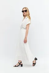 Vestido midi blanco con cuello camisero, escote en V, mangas cortas y falda plisada. Incluye cinturón con hebilla forrada.
