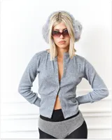 Cardigan gris de manga larga con hilera de botones broche a lo largo de toda la prenda.