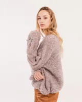 Buzo tejido a mano con lana, color rosa con motas de colores. Diseño oversized, largo entre la cintura y la cadera, con detalle de trenzas en las mangas.