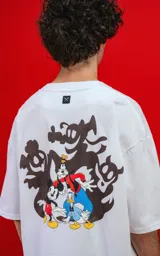 Remera oversize de algodón premium color blanco, con cuello redondo y manga corta. Presenta un pequeño estampado del personaje Mickey Mouse en el lado izquierdo del pecho.