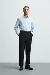 Camisa blanca de manga larga con cuello italiano y cierre frontal de botonadura. Corte regular fit.