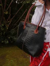 Bolso shopper de cuero azul con textura crocco, manijas largas marrones y costuras artesanales visibles en los bordes.