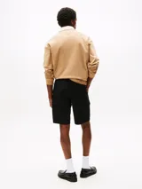 Pantalón corto tipo cargo de sarga de algodón elástico, color negro, con corte amplio y pierna recta. Presenta bolsillos ribeteados en la cintura, bolsillos laterales tipo cargo y un bolsillo trasero de ojal con botón.