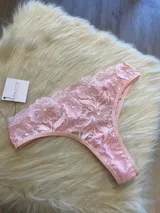 Vedetina de encaje floral color rosa, con cintura elástica y refuerzo de algodón.