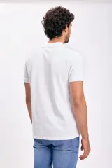 Remera polo blanca de piqué de algodón, con cuello clásico y tapeta de dos botones. Corte recto y mangas cortas.