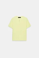 Top de punto de tacto suave, color amarillo, con cuello redondo y cierre frontal de botones. Manga corta.