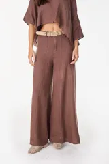 Pantalón de lino italiano con diseño estampado a rayas verticales en tonos negro y beige, de tiro medio y corte ancho.