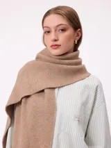 Bufanda de tejido de punto grueso en color negro, con etiqueta de la marca Rusty en uno de los extremos.