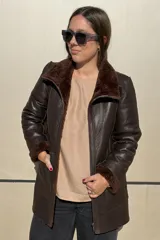 Campera reversible de cuero ovino, color azul marino, con interior de piel sintética blanca. Presenta cuello alto, cierre frontal y bolsillos frontales aplicados.