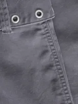 Minifalda gris de tiro medio, confeccionada en denim, con diseño de corte recto y presillas con cinturón ancho decorado con ojales metálicos y hebilla rectangular.