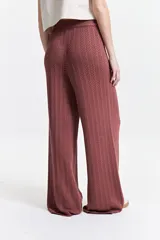 Pantalón de punto color ladrillo con diseño calado, cintura elástica y corte palazzo.