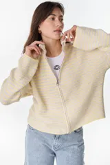 Campera de punto a rayas horizontales en tonos amarillo pastel y lila, con cuello alto, cierre frontal completo y mangas largas con bordado distintivo en la manga.
