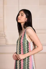 Vestido largo de tejido de punto con estampado de zig-zag vertical en tonos rosados, verdes, beige y lila. Presenta escote en V pronunciado tanto en el frente como en la espalda, con vivos de punto con lurex.