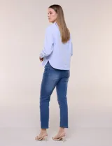 Camisa de algodón celeste con patrón de milrayas finas y aplicaciones florales en relieve deshilachado en el frente. Cuenta con cuello camisero tradicional, cierre frontal con botones, mangas largas con puños abotonados y corte semi holgado.