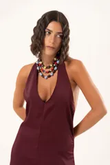 Vestido largo de color bordó, con escote halter profundo y corte a la altura de la cadera con falda amplia.