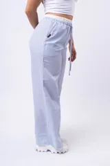 Pantalon de corte amplio y tiro bajo, confeccionado en tela de franela con estampado de cuadros en tonos blanco, negro y gris. Cuenta con cintura elástica con cordón ajustable y bolsillos laterales.