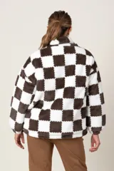 Campera de poliéster símil piel, con estampado a cuadros blancos y negros, cierre frontal y bolsillos laterales.