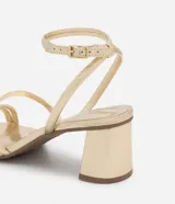 Sandalias doradas de tacón bloque, con tiras finas y cierre de hebilla en el tobillo.