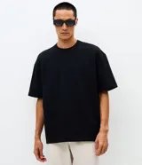 Remera masculina de corte boxy, color marrón oscuro, con cuello redondo y mangas cortas. Confeccionada en malla pesada con textura gomosa.