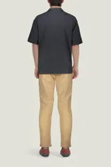 Camisa de algodón color negro, con cuello tipo cubano, manga corta y bolsillo frontal.