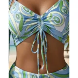 Conjunto de traje de baño de tres piezas con estampado de hojas tropicales en tonos blanco y negro. Incluye un top tipo tankini con cordón ajustable en el centro, un short de tiro alto y una camisa abierta de manga larga tipo salida de baño.