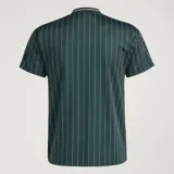 Camiseta de punto oversized verde oscuro de la colección Icons de Adidas, inspirada en los años 80, con rayas diplomáticas blancas, las icónicas tres tiras de la marca en las mangas, cuello redondo y el logotipo del trébol bordado junto al escudo vintage de la Juventus.