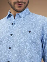 Camisa de manga larga con estampado floral celeste y blanco, confeccionada en algodón.