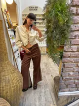 Pantalon sastrero de lino color marrón con paneles laterales en contraste beige, diseño de tiro alto y corte recto. Presenta un bordado de caballo en el bolsillo frontal.