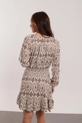 Vestido largo color crudo con estampado abstracto en tonos marrones y grises. Escote cuadrado con lazo ajustable, mangas largas y falda con elástico en la cintura.