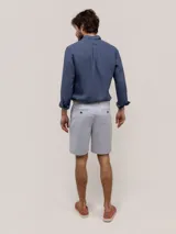 Bermuda de hombre de corte regular fit, color gris, con cierre de cremallera y botón, bolsillos laterales y traseros.