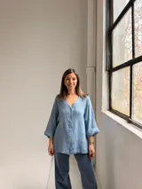 Camisa oversize de lino color celeste, con escote en V, cierre frontal con botones y mangas largas holgadas.