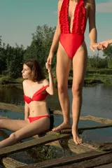 Top de bikini rojo con diseño estilo off-shoulder, con escote corazón y tirantes caídos sobre los hombros.
