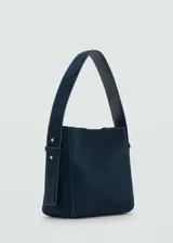 Bolso de hombro de tamaño mediano confeccionado en piel de serraje color azul marino. Cuenta con un asa corta ajustable, cierre de botón magnético y forro interior.