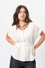 Blusa beige melange con escote en V, manga corta caída, botones metálicos frontales y pinzas que marcan la cintura.