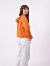 Hoodie color beige de corte holgado, con capucha y puños con rayas blancas.