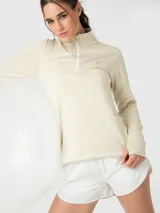 Polera de manga larga color marfil melange, con cuello alto y cierre frontal parcial. Presenta diseño deportivo con costuras visibles y puños con abertura para el pulgar.